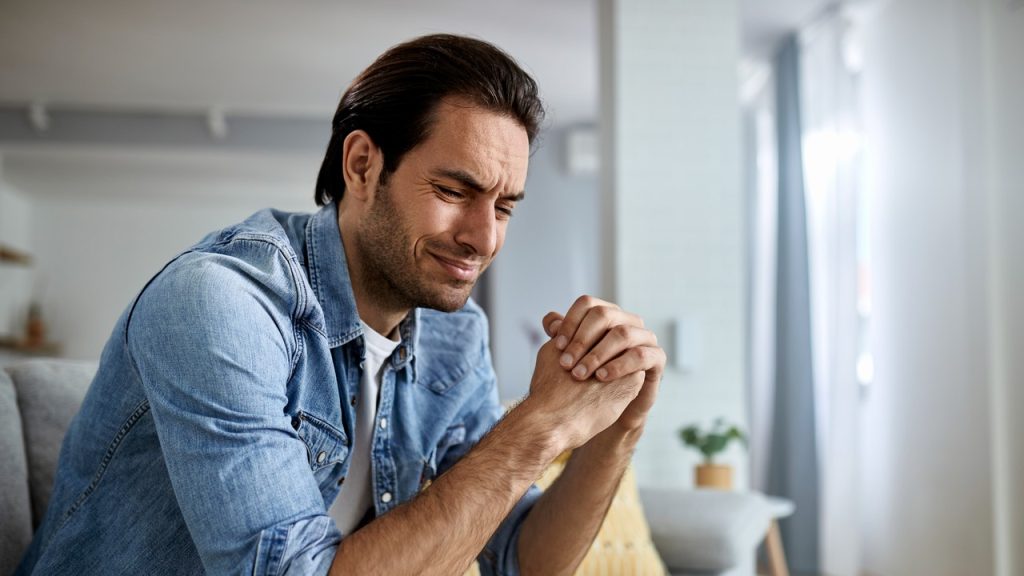 Álláskereső férfi otthon ül a kanapén